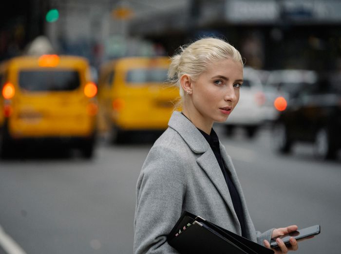 A seller checking orders on her phone in the city